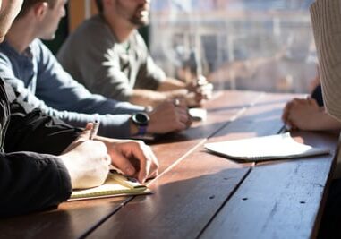 employees hands at table, coworkers meeting