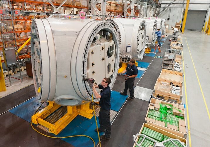 factory workers tend to large machinery